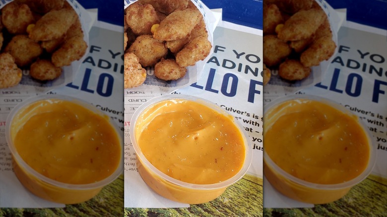 One small serving of Culver's cheese sauce next to cheese curds