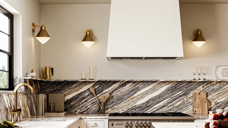 Kitchen with bold marble backsplash and brass wall sconces