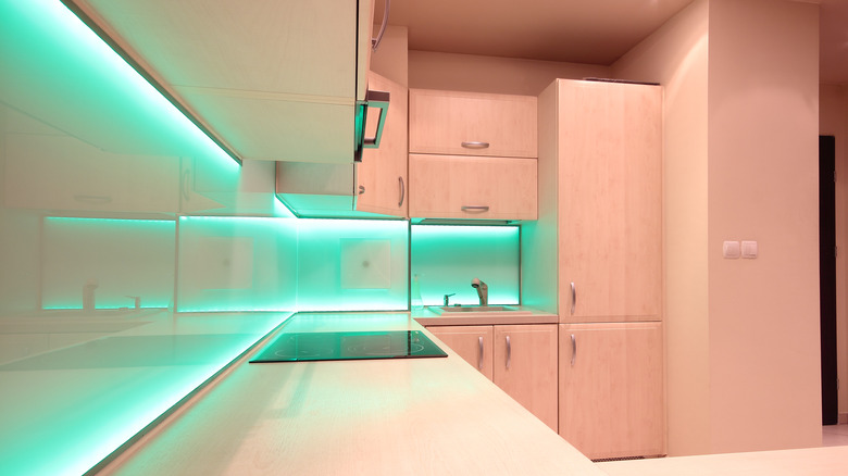 Kitchen with teal LED lights lining counter and under cabinets