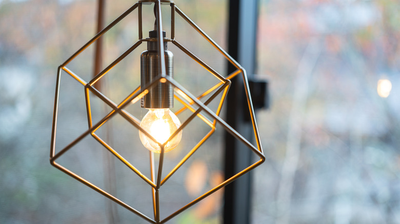 close up of geometric light hung in front of windows