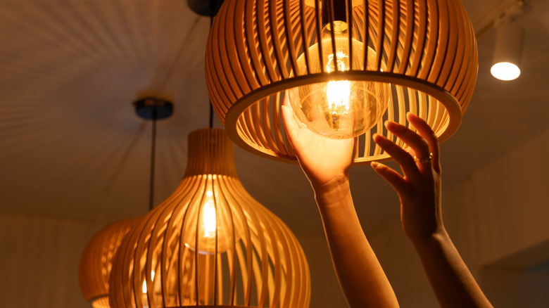 close up of woman adding light bulb to fixture