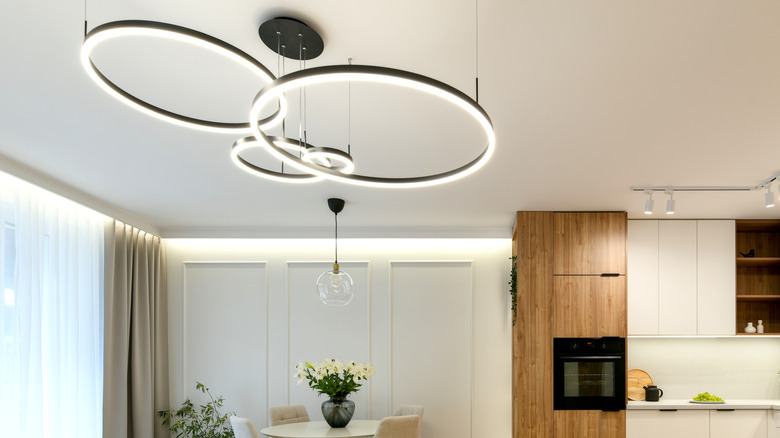Circular LED light fixture in all-white modern kitchen