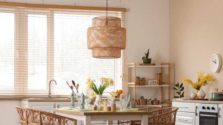 boho-style kitchen with woven rattan light fixture above dining area