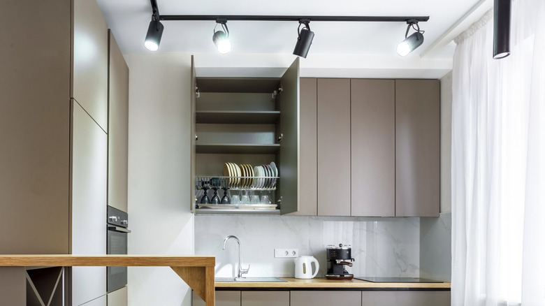 Minimalist kitchen with black spotlight track lighting on ceiling