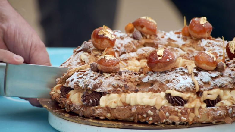 Paris-Brest being sliced with knife