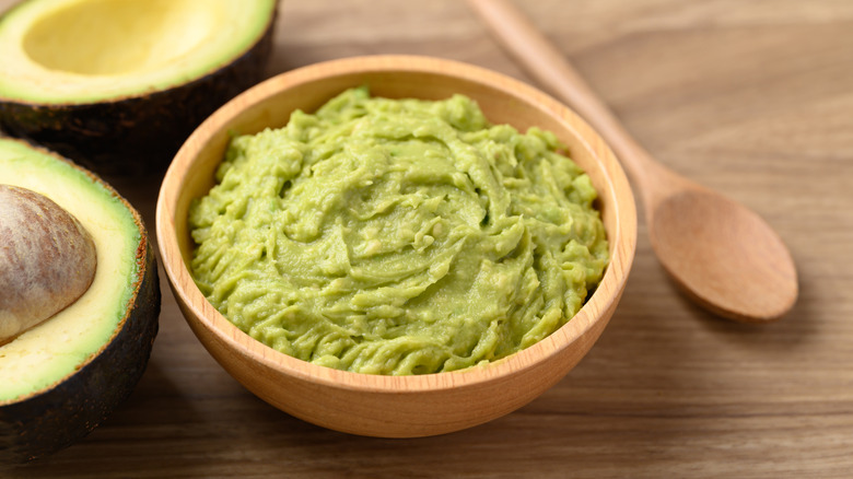 Guacamole in wooden bowl on table
