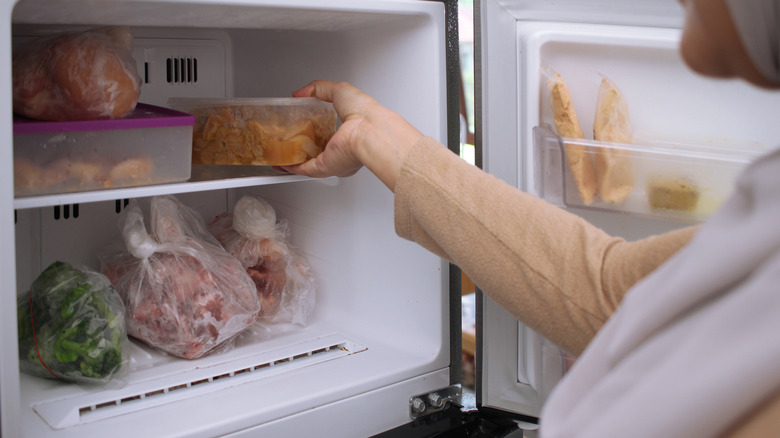 Hand pulling a container from a freezer