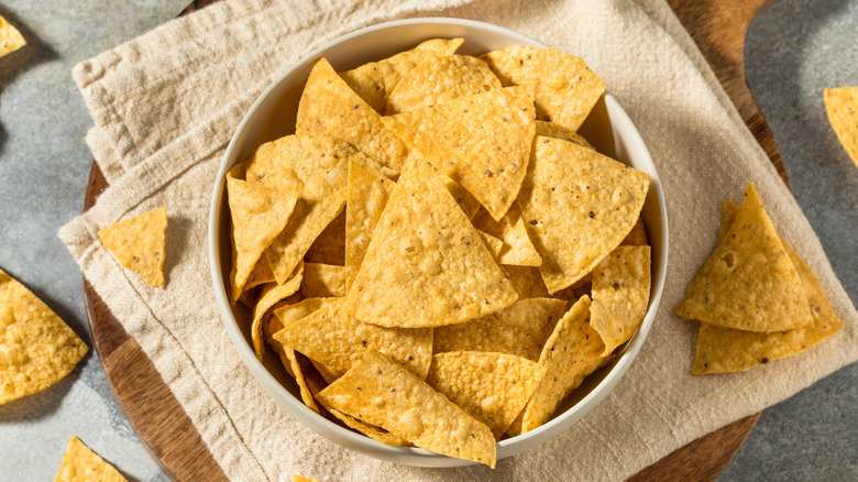 Tortilla chips in a white bowl on top of a towel