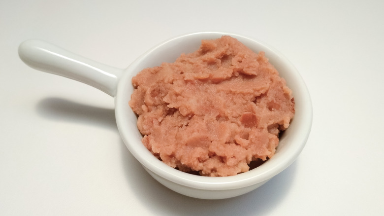 Refried beans in white dish on white table