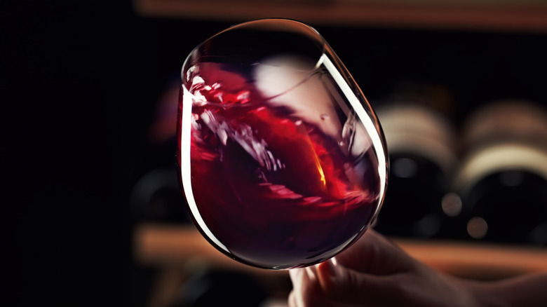 Person swirling glass of red wine