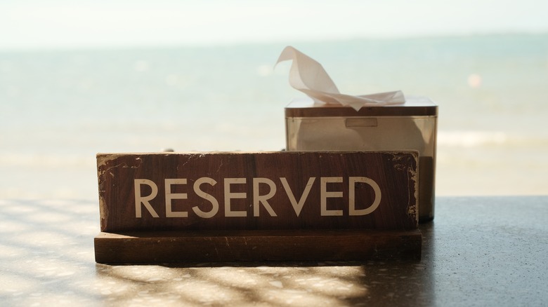 Reserved sign on table in front of box of napkins