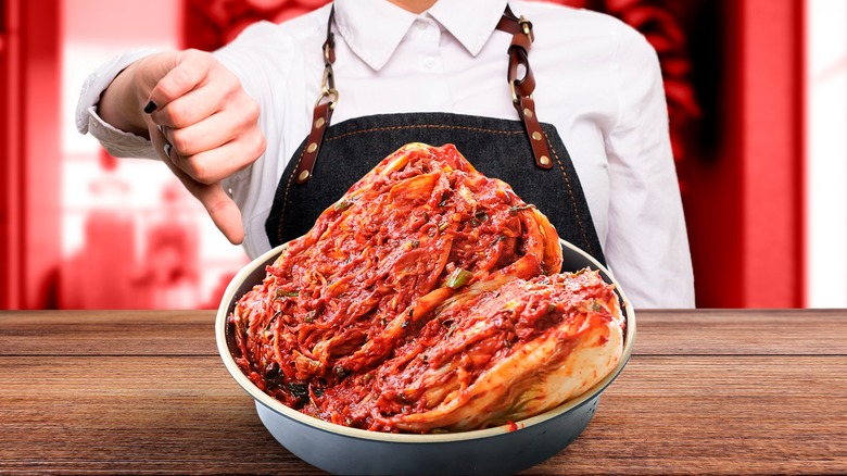 woman with thumbs down behind kimchi