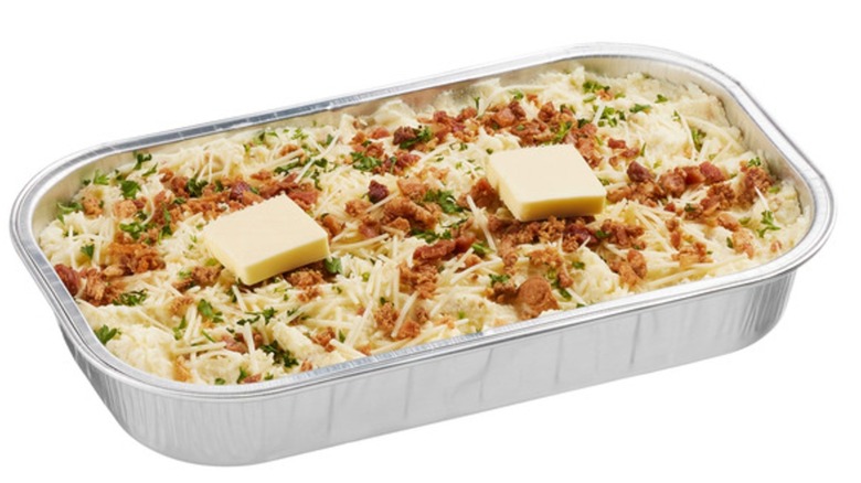 Tray of loaded mashed potatoes with two slabs of butter on top