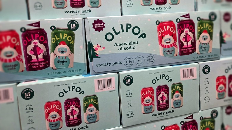 Several 15-can cases of Olipop, with three flavors shown on packaging