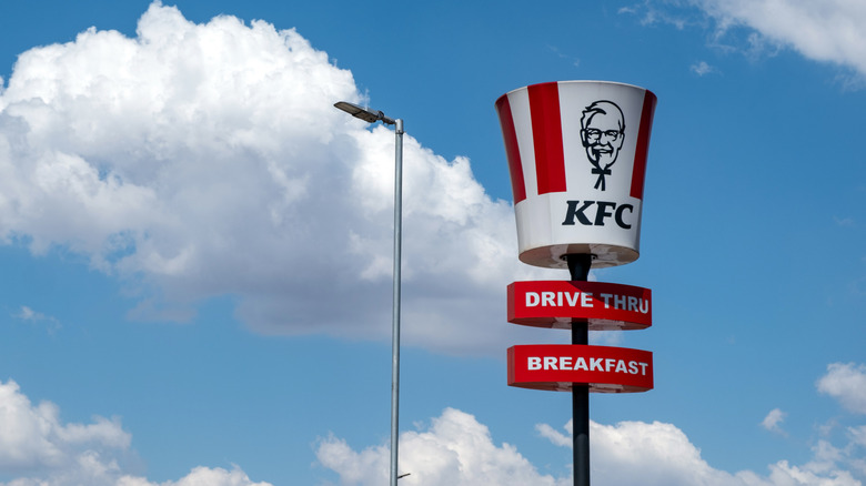A KFC bucket against a blue sky with clouds