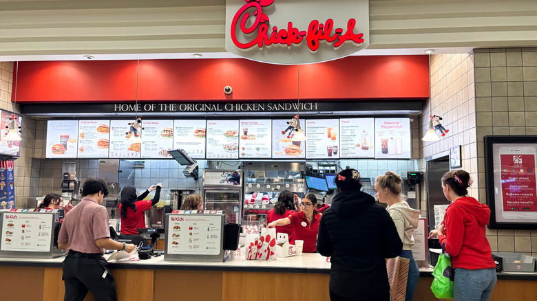A Chick-fil-A restaurant with customers at counter inside a mall