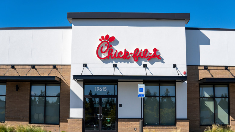Chick-fil-a fast food restaurant with empty parking lot against blue sky