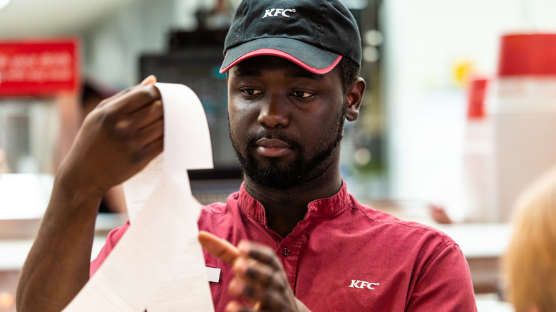 Close up of KFC worker holding receipt