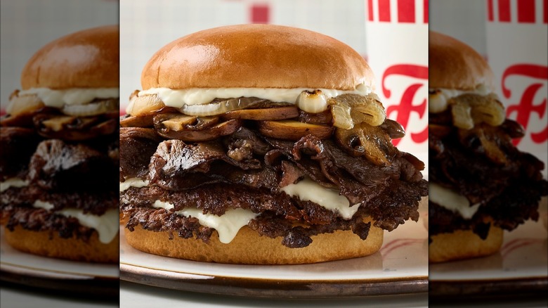 Freddy's Prime Rib Steakburger with mushrooms and onions on white plate