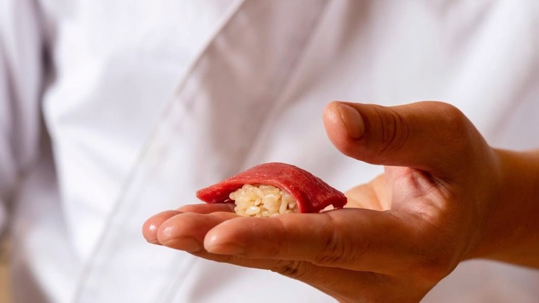 Chef from Icca holding a piece of sushi