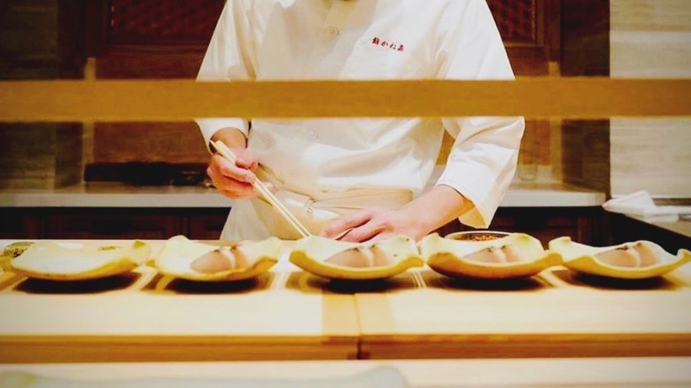 Chef preparing dishes as Sushi Kaneyoshi