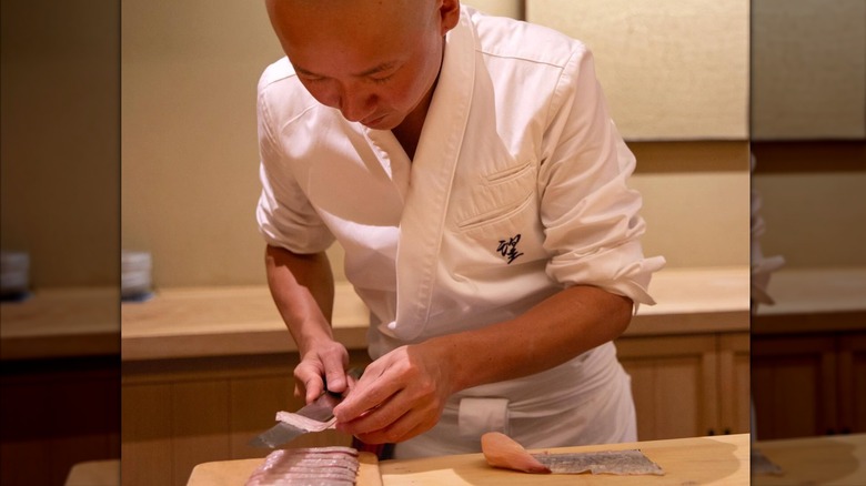 Chef preparing raw fish at Sushi Noz