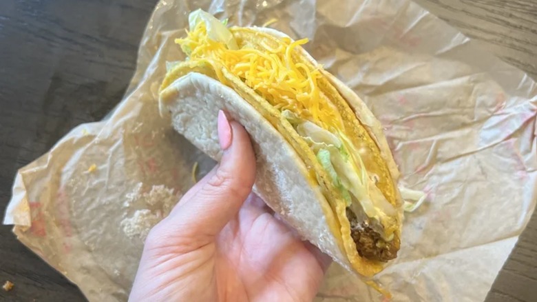 Hand holding Cheesy Gordita Crunch at Taco Bell
