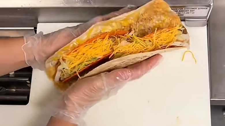 Employee making a giant cheesy gordita crunch