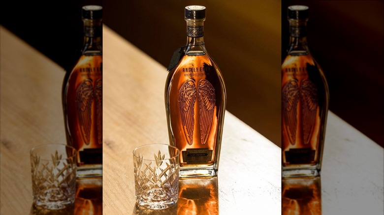 Bottle of Angel's Envy Cask Strength with empty glass on table