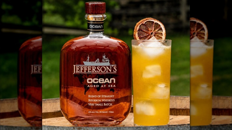 Bottle of Jefferson's Ocean Aged at Sea on barrel outside with cocktail