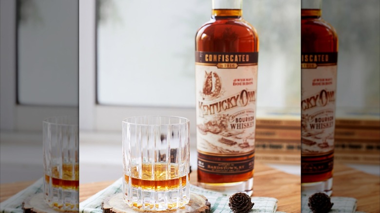 Bottle of Kentucky Owl Confiscated with glass and pinecone
