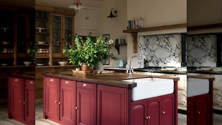 Rustic kitchen with dark wood countertops and shelving, and a burgundy red island.
