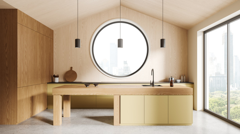 Spacious kitchen with a light wood interior and butter yellow lower cabinets.
