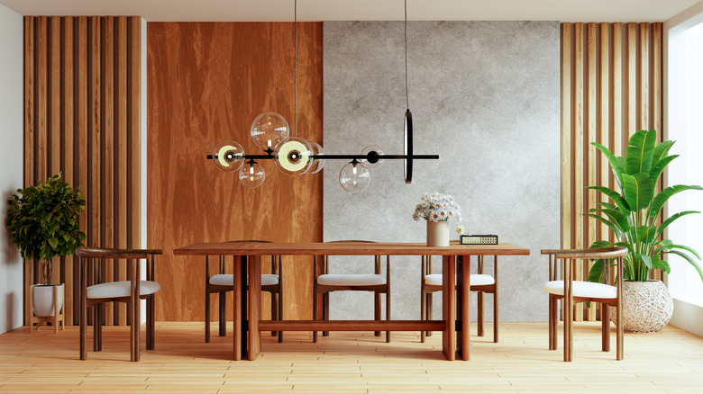 A dining area with wooden elements in various textures, and a single concrete gray wall panel.