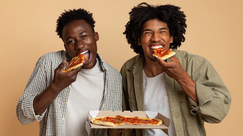 Black men eating pizza