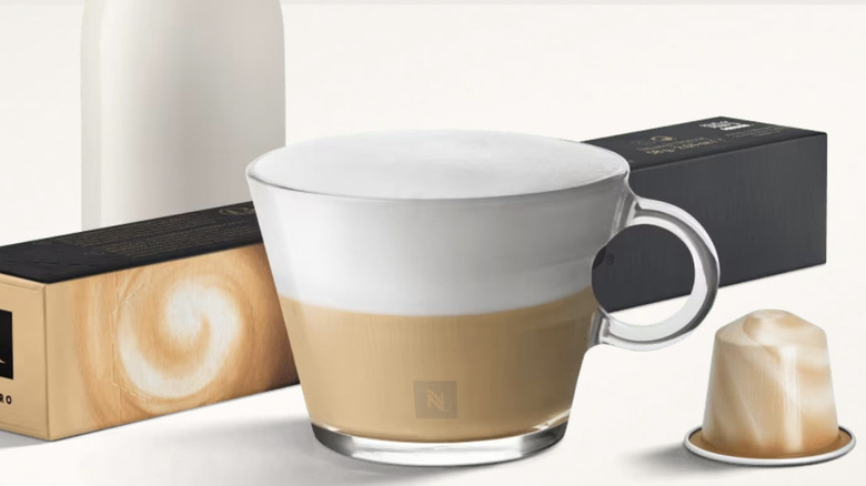 A mug of coffee, a Nespresso capsule, and a pack of Nespresso capsules