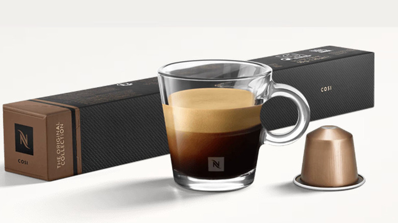 A mug of coffee, a Nespresso capsule, and a pack of Nespresso capsules labelled Cosi