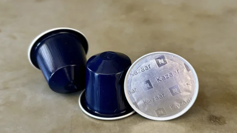 Three Kazaar coffee pods on a brown surface