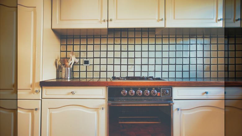 1980s stove area with tiled backsplash and countertop