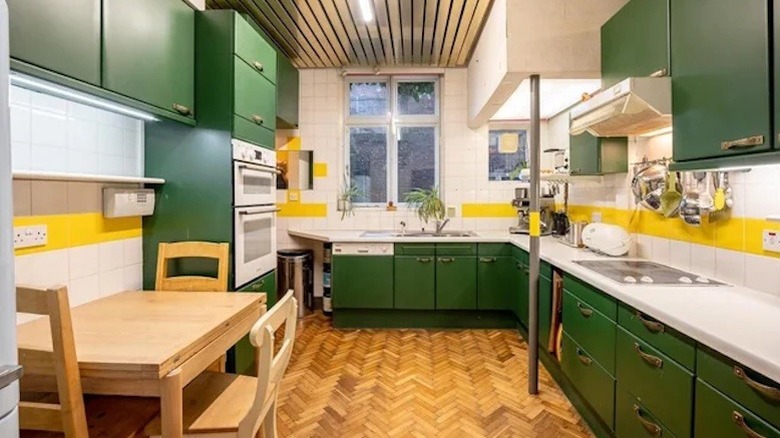 Retro kitchen with dark green cabinets and bright yellow accents