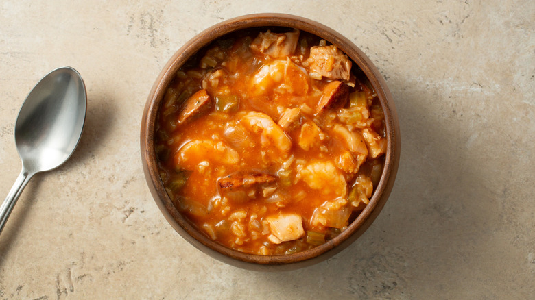 Wooden bowl of classic jambalaya with spoon