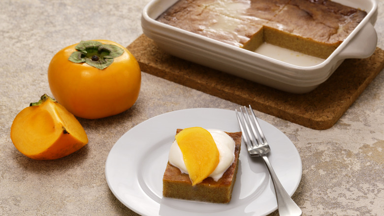 Persimmon pudding on plate with cream