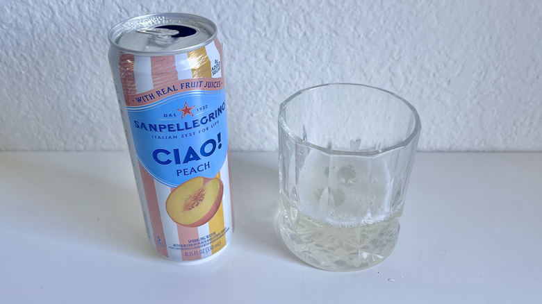Open can of San Pellegrino's Ciao Peach Sparkling Water with a glass on the side