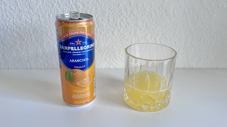 Glass and a can of San Pellegrino Aranciata Orange Sparkling Beverage