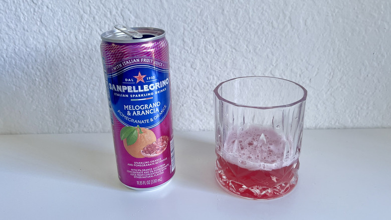 Open can of Melgrano and Arancia Italian Sparkling Drink with a filled glass on the side