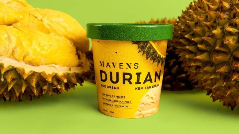 A box of Mavens Durian Ice Cream placed next to open and whole durian