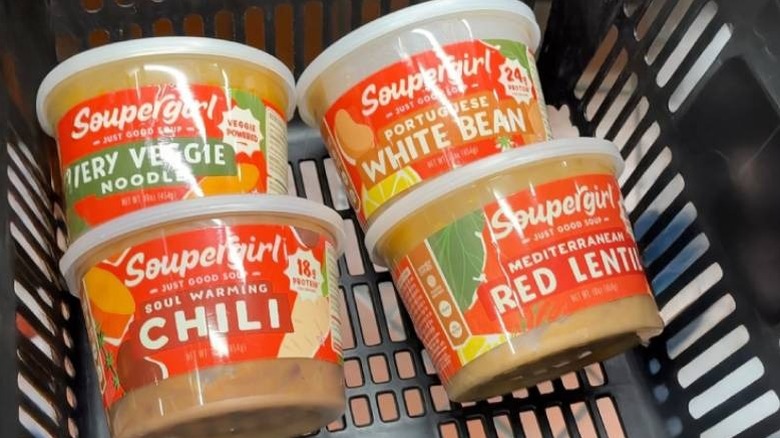 Several boxes of Soupergirl soups placed in a shopping cart