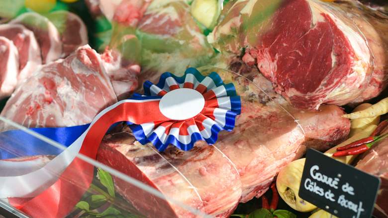 Award winning meat displayed in case with red, white, and blue ribbon.