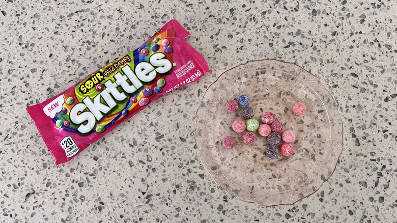 Sour Wild Berry Skittles bag with candies on a plate