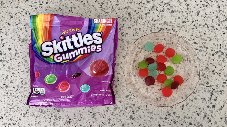 Bag of Wild Berry Skittles Gummies with candies on a plate